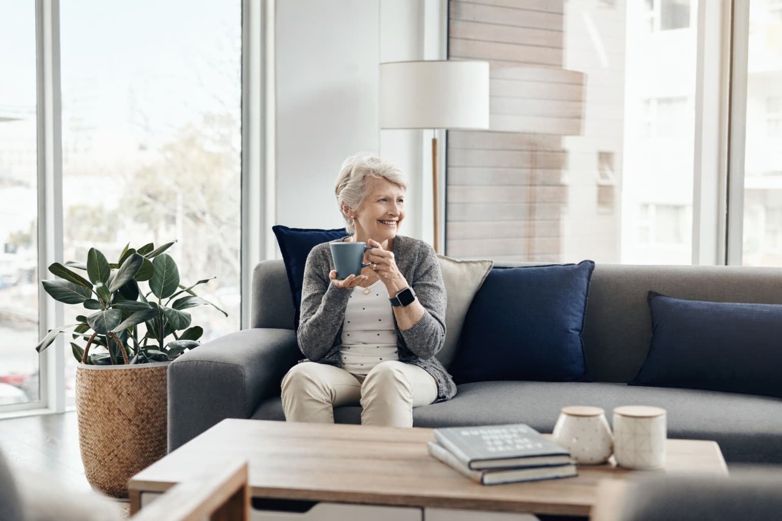 Older woman relaxing on a couch in a bright living room